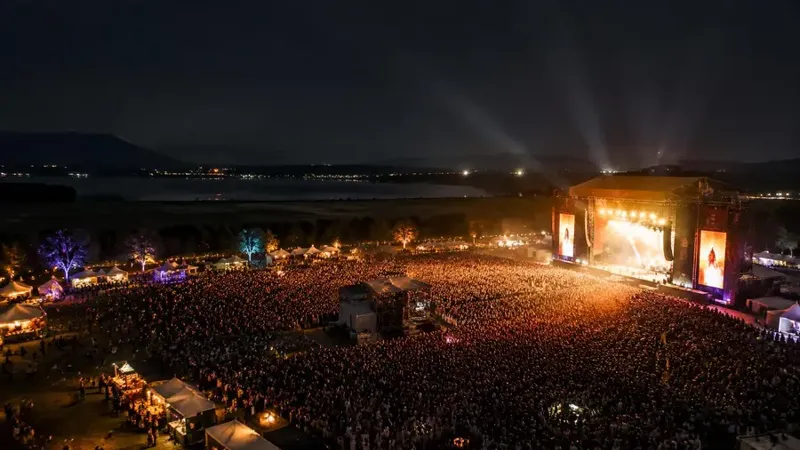 Palco iluminado de evento musical ao ar livre à noite