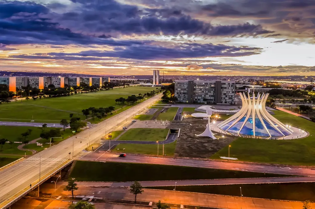 Vista aérea de Brasília ao entardecer, com a Catedral Metropolitana e a Esplanada dos Ministérios